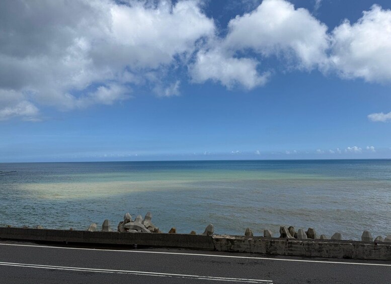 A coastal road with a guardrail and ocean view. 5
