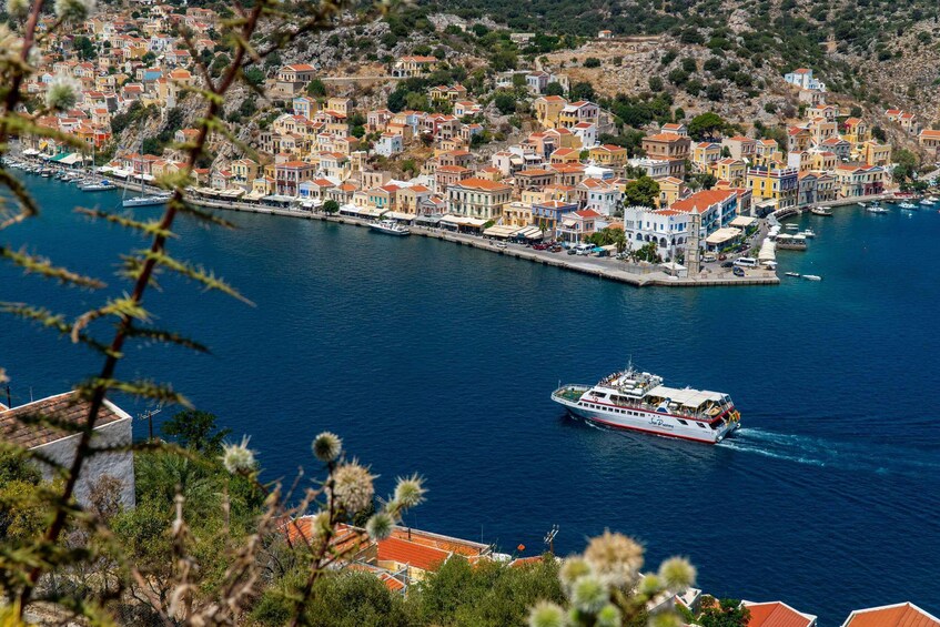 A coastal town with colorful buildings and a ferry in the water. 1