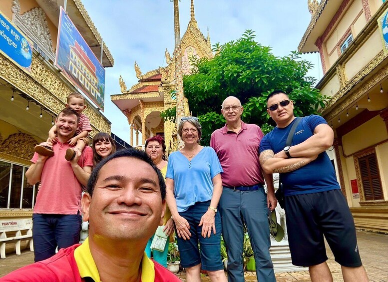 A group of people standing in front of a temple with ornate architecture. 1