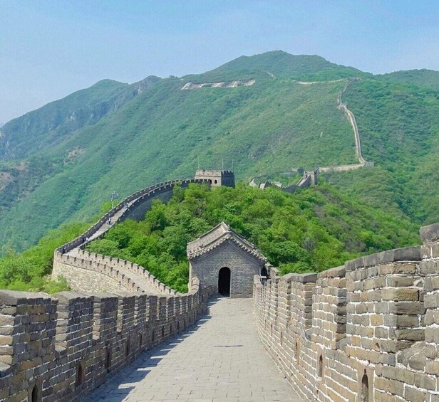 Kiinan suuri muuri kiemurtelee vehreiden, vihreiden kukkuloiden halki. 2