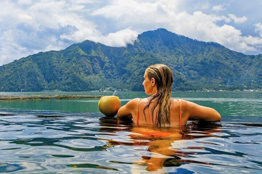 A person in a body of water with mountains in the background. 2