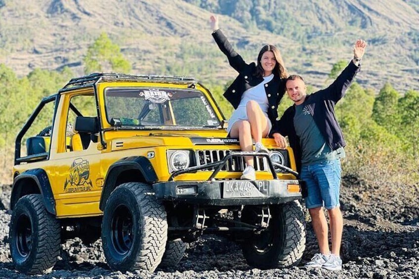 A yellow off-road vehicle with large tires parked on a rocky terrain. 3