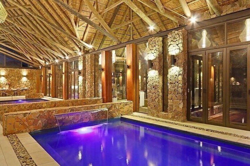 Una piscina interior con paredes de piedra y vigas de madera. 3