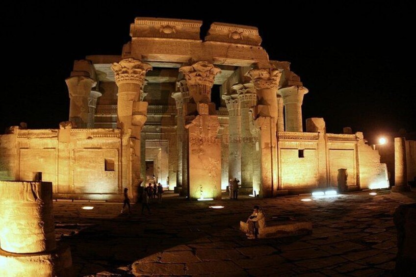 An ancient temple at night with illuminated columns and a grand entrance. 2