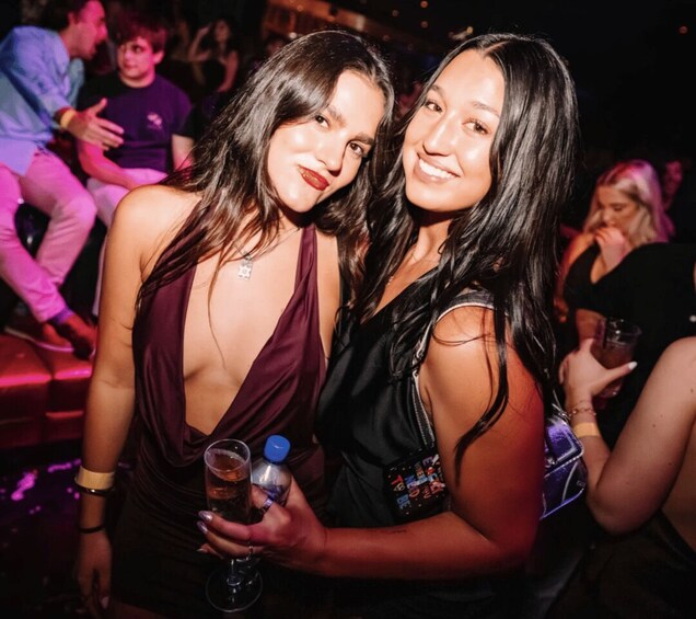 Two women at a social event, one holding a drink. 4