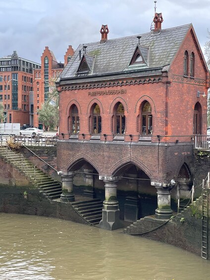 A historic building with arched windows and a sign reading "FLEETSCHLOSSCHEN" across the front. 1