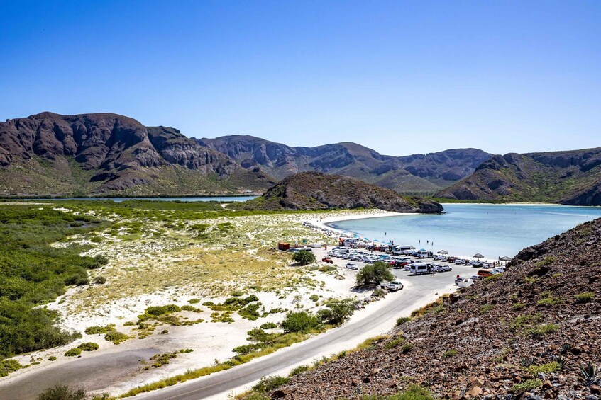 A coastal road with a parking area and a beach. 5