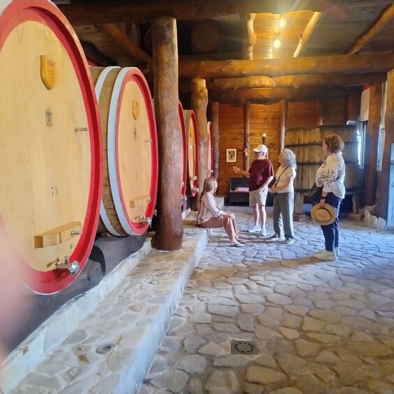A cellar with wooden barrels, stone flooring, and a rustic interior. 2