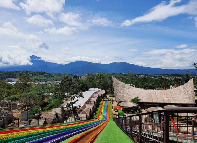 A rainbow slide at an amusement park with a mountainous backdrop. 4