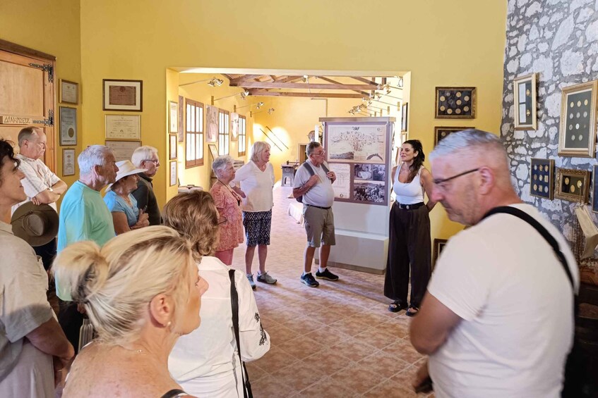 A group of people in a museum or gallery with framed pictures on the walls and a large informational display. 4