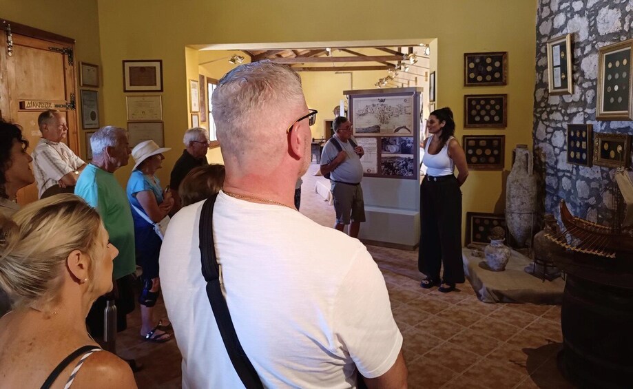 A group of people in a museum or gallery with stone walls and framed artwork. 2