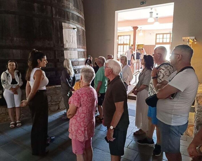 A group of people standing in a building with a stone wall and a wooden door. 5