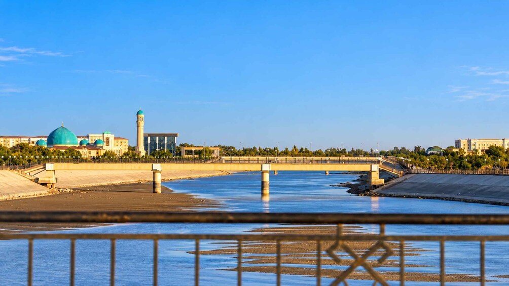 A river with a bridge, a mosque with blue domes, and a tall minaret. 5