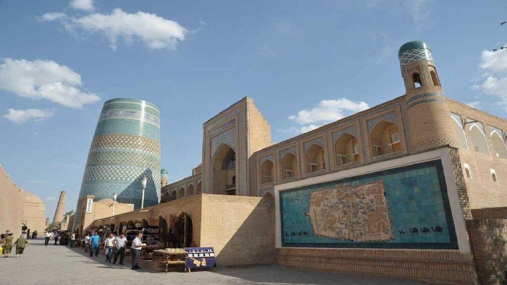 A historic site with large cylindrical towers and a detailed mural. 4
