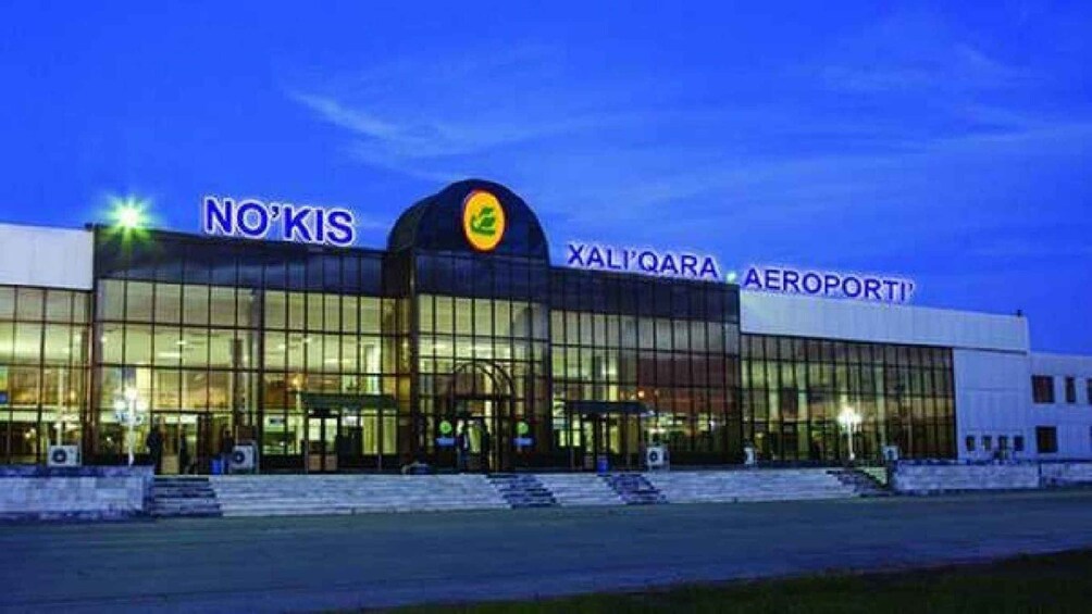 A modern airport terminal with 'NO KIS' and 'XALIQARA AEROPORT' signage. 5