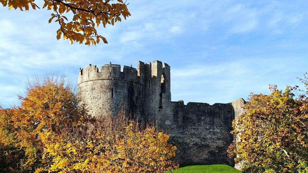 A medieval castle surrounded by autumn foliage. 1