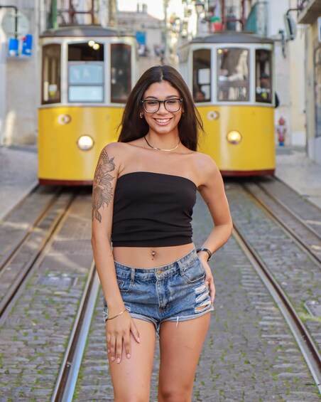 A person standing on train tracks with a tram in the background. 2
