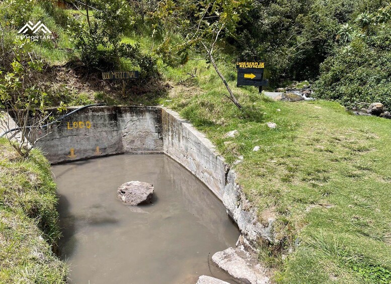 A stone structure with a water channel, surrounded by greenery and a sign indicating 'Lodo Medicinal'. 4