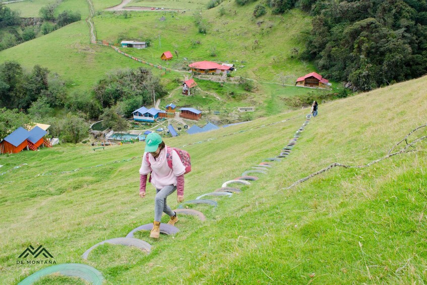 A person hiking on a grassy hill with houses in the background. 5