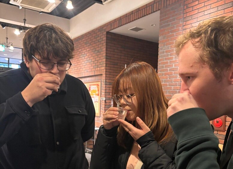 Three people in a cafe with brick walls and hanging lights. 2