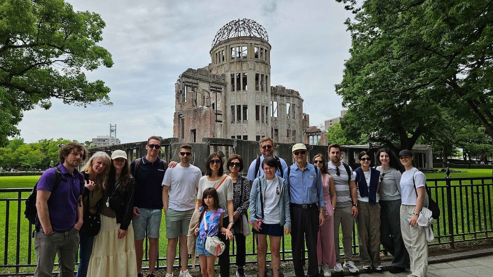 A group of people standing in front of a historical building with a large circular structure on top. 3