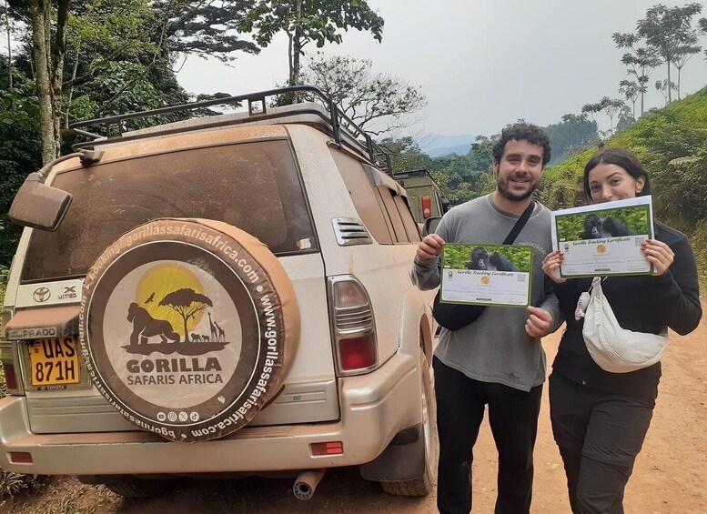 A vehicle with a 'Gorilla Safari' decal and two people holding certificates. 1