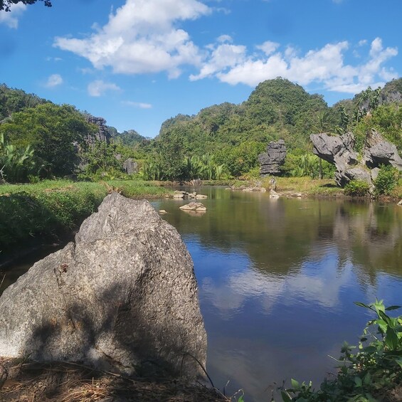 A calm river with rocks and lush greenery. 2