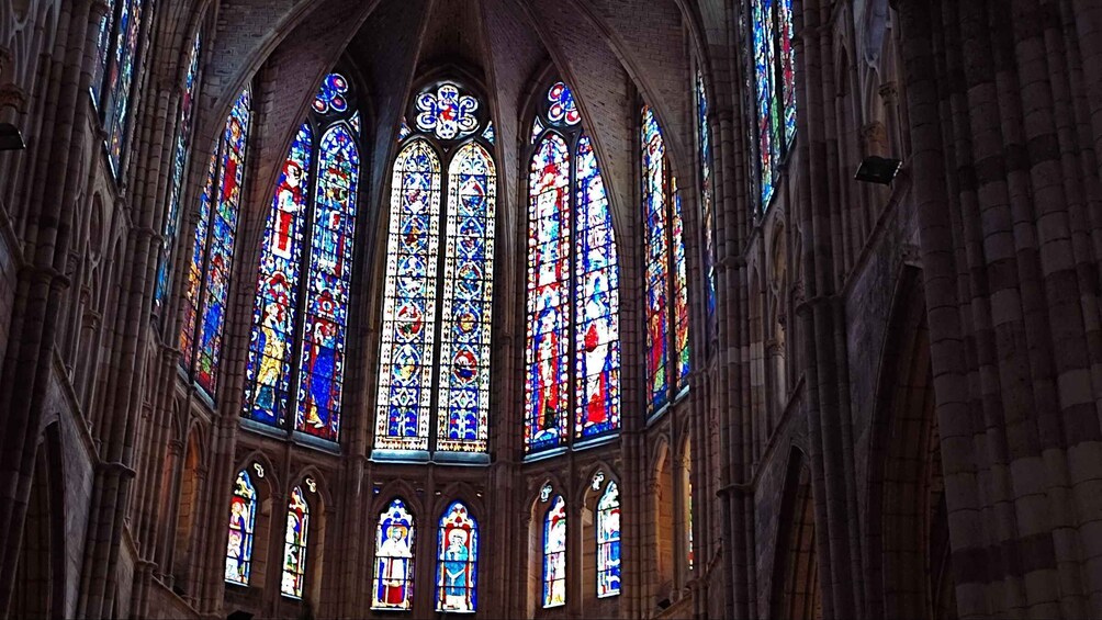 A cathedral interior with Gothic architecture and colorful stained glass windows. 4