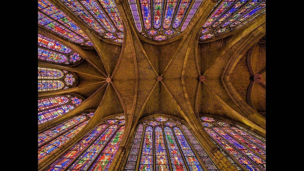 A cathedral interior with Gothic architecture, stained glass windows, and a vaulted ceiling. 5