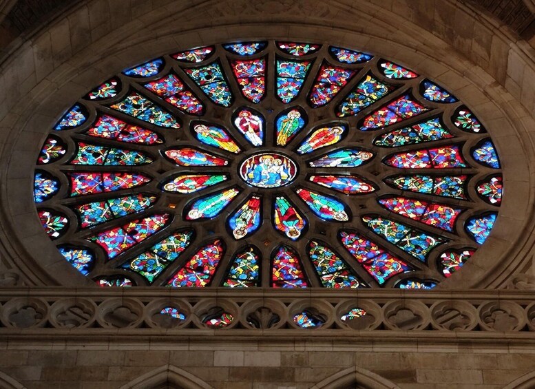 A large circular stained glass window with intricate designs and multiple colors. 2