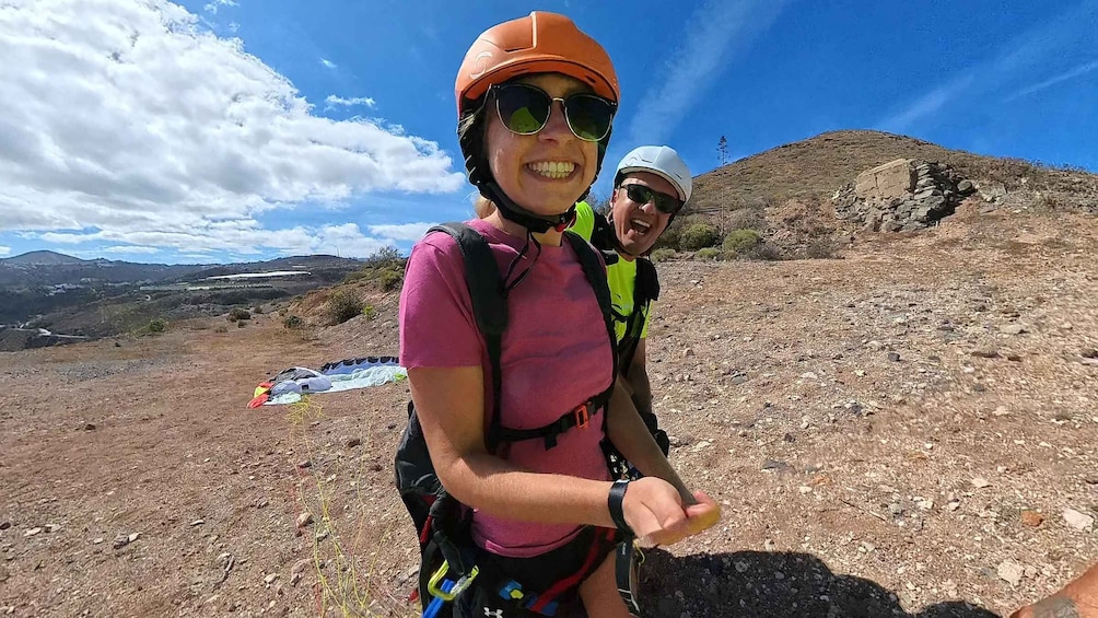 Two people hiking on a rocky trail with a clear sky and distant mountains. 2
