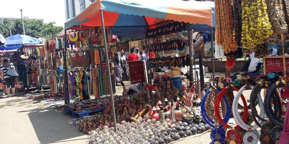 A bustling outdoor market with various stalls selling colorful jewelry and decorative items. 4