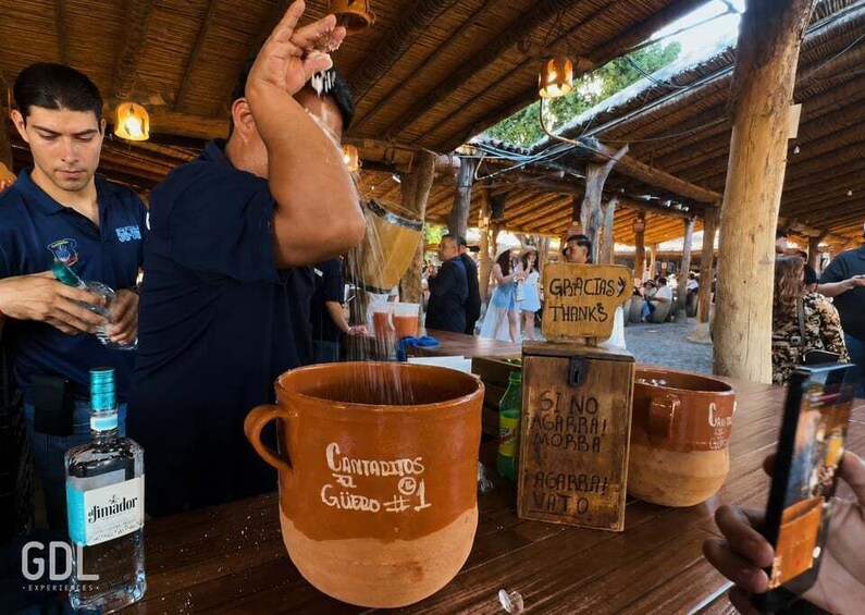 A rustic outdoor setting with wooden structures and people engaged in social activities. 3