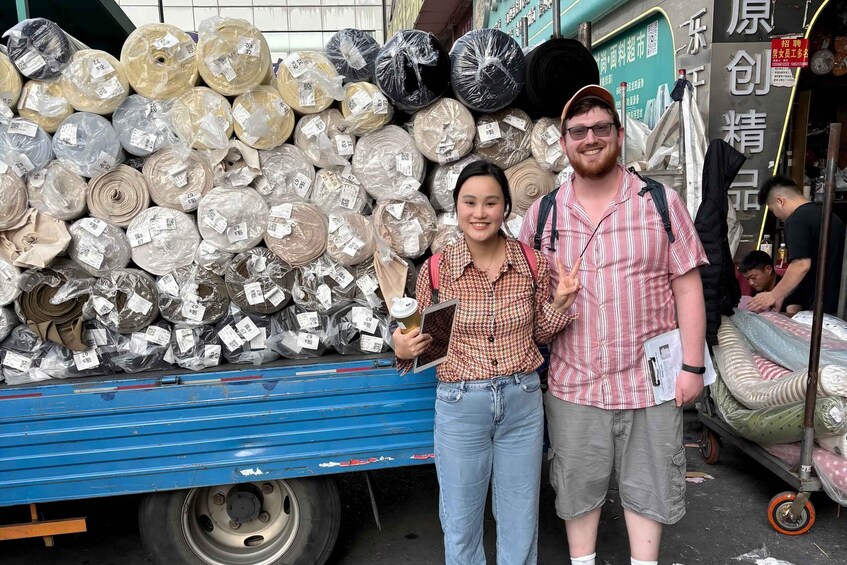 Two people standing in front of a truck loaded with various packaged items. 5