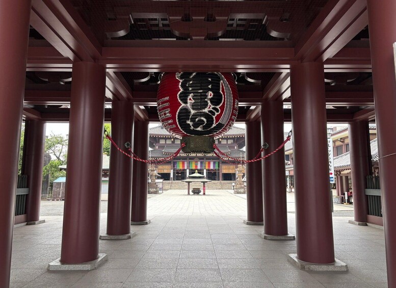 A traditional Japanese building with red pillars and a hanging lantern. 2