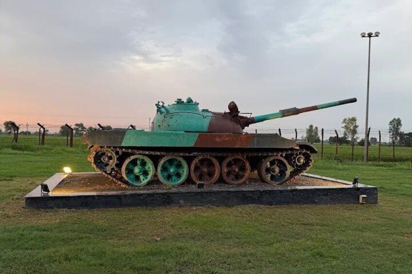 A green and brown tank on display with a light on the left. 4