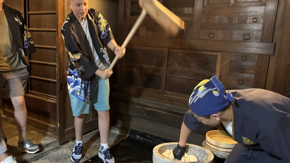 A person pounding dough in a stone mortar. 2