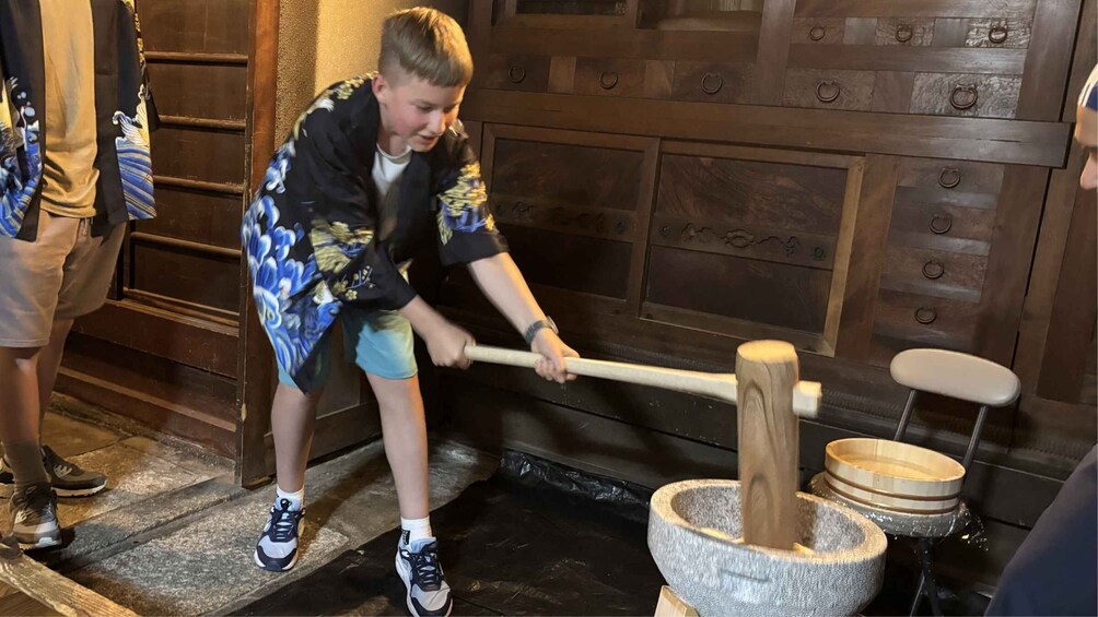 A person using a wooden mallet to pound a stone mortar. 5