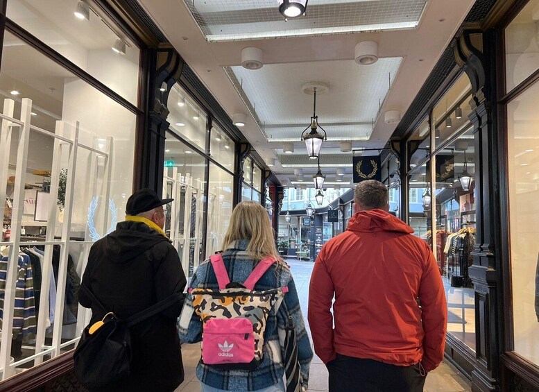 A shopping corridor with glass storefronts and hanging lights. 4