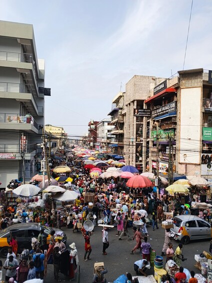 A bustling street market with numerous stalls and people. 4