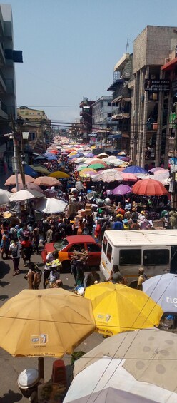 A busy street market with numerous colorful umbrellas and people shopping. 5