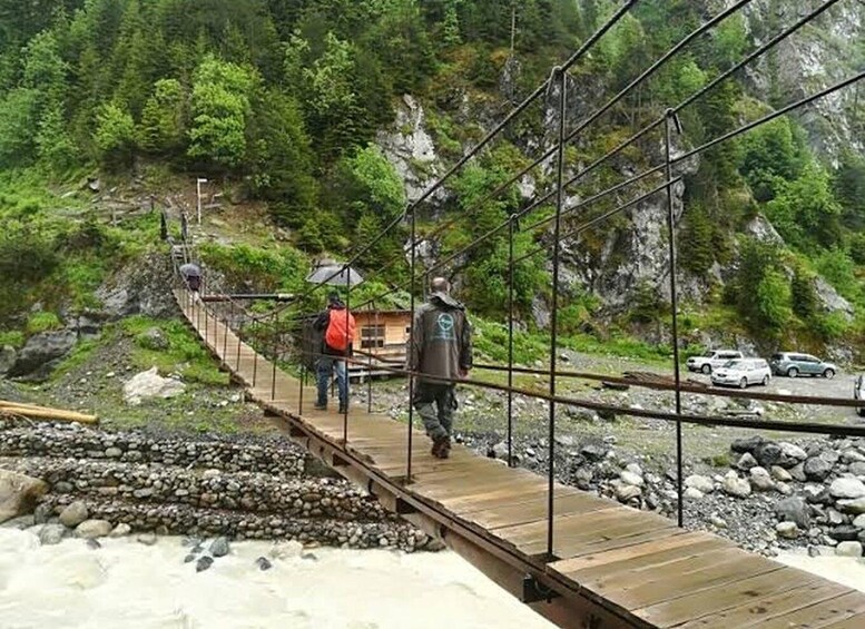 A wooden pedestrian bridge over a river with people walking on it. 5