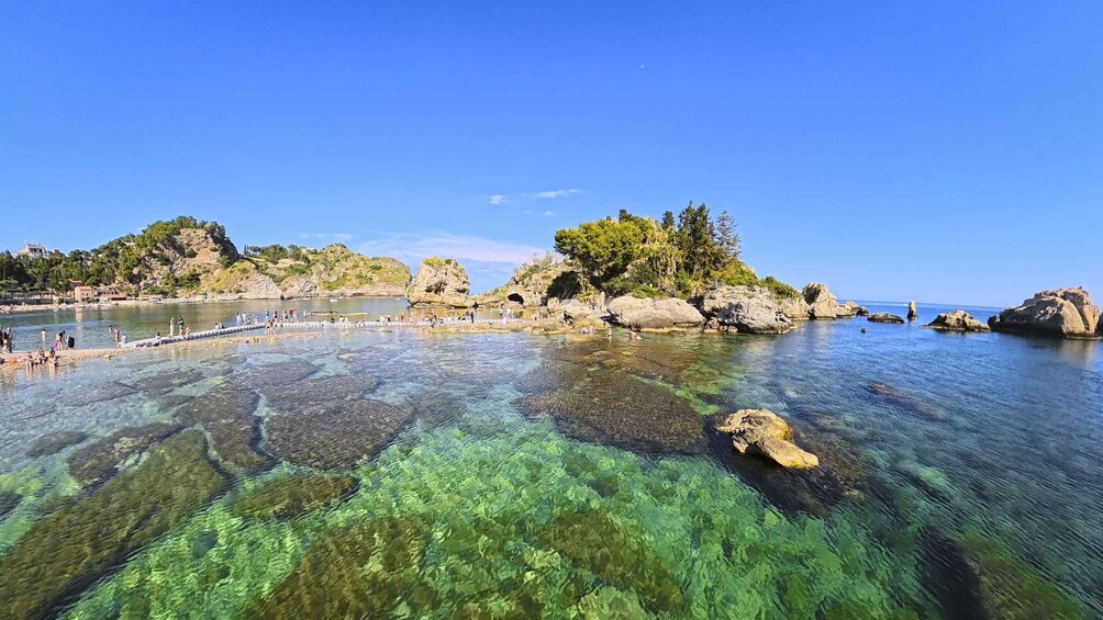 A clear coastal area with rocky outcrops and a pier. 4