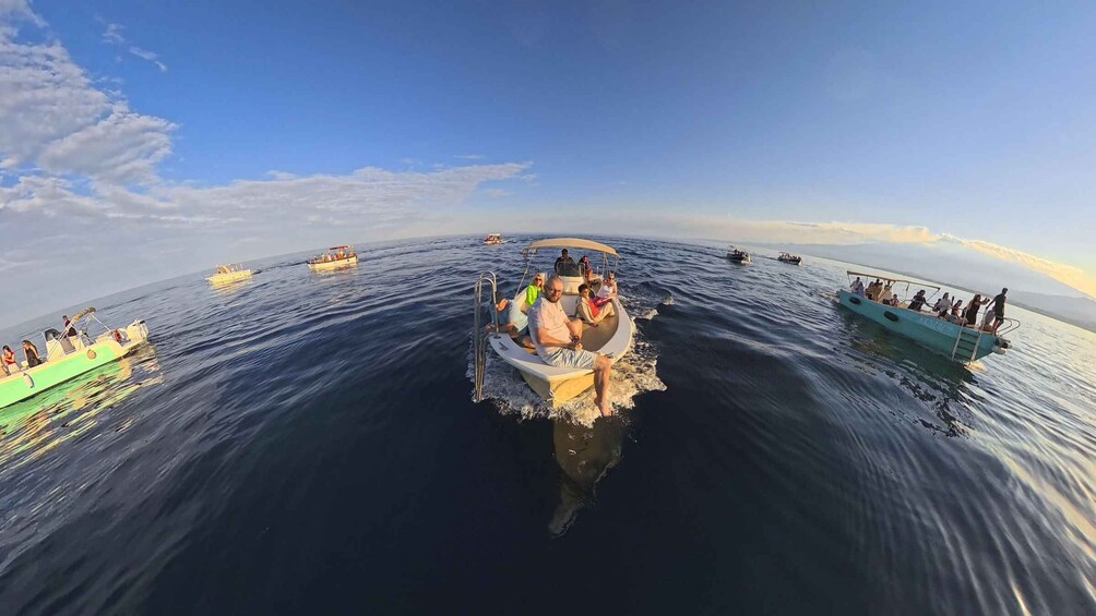 A group of boats on a calm sea with clear skies. 3