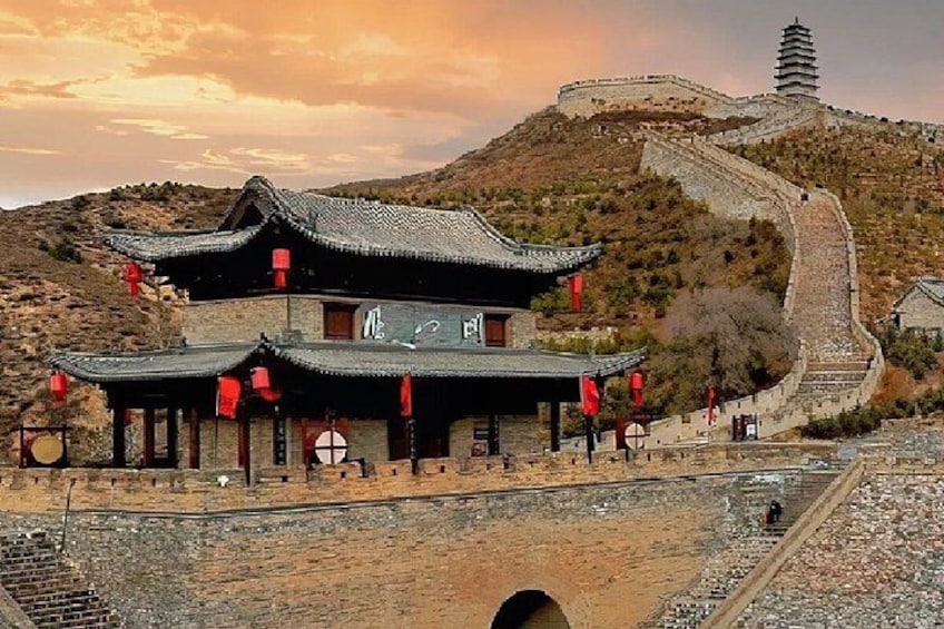 Un edificio tradicional chino con una pagoda en una colina, un puente de piedra y un muro de piedra. 1