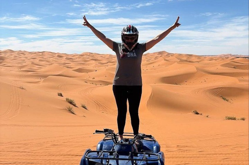 Una persona sobre un cuatrimoto en un desierto, con dunas de arena al fondo. 5