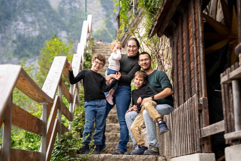 A family on a wooden staircase with a mountainous backdrop. 3