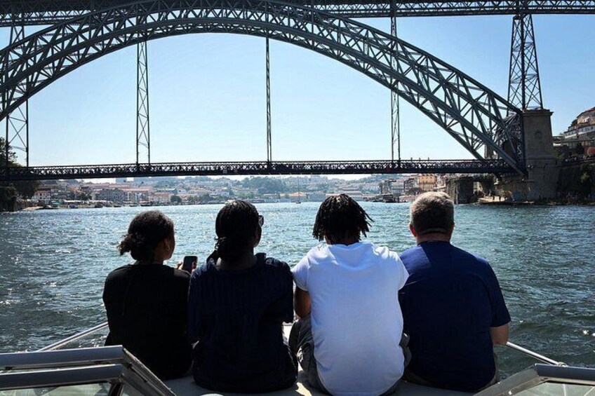 A bridge over water with people on a boat. 2