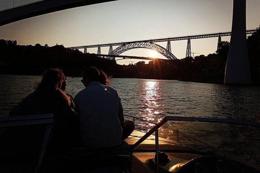 A sunset over a bridge with a boat and people on it. 5