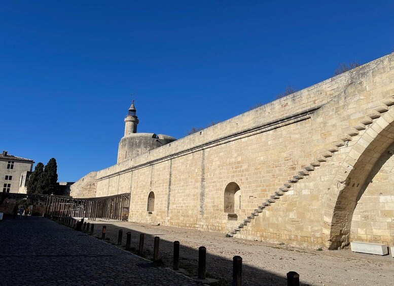 A stone wall with a tower and a paved walkway. 2
